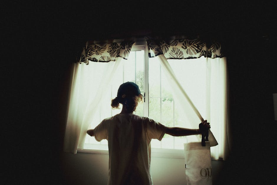 Woman adjusting elegant window shades in a sunlit room